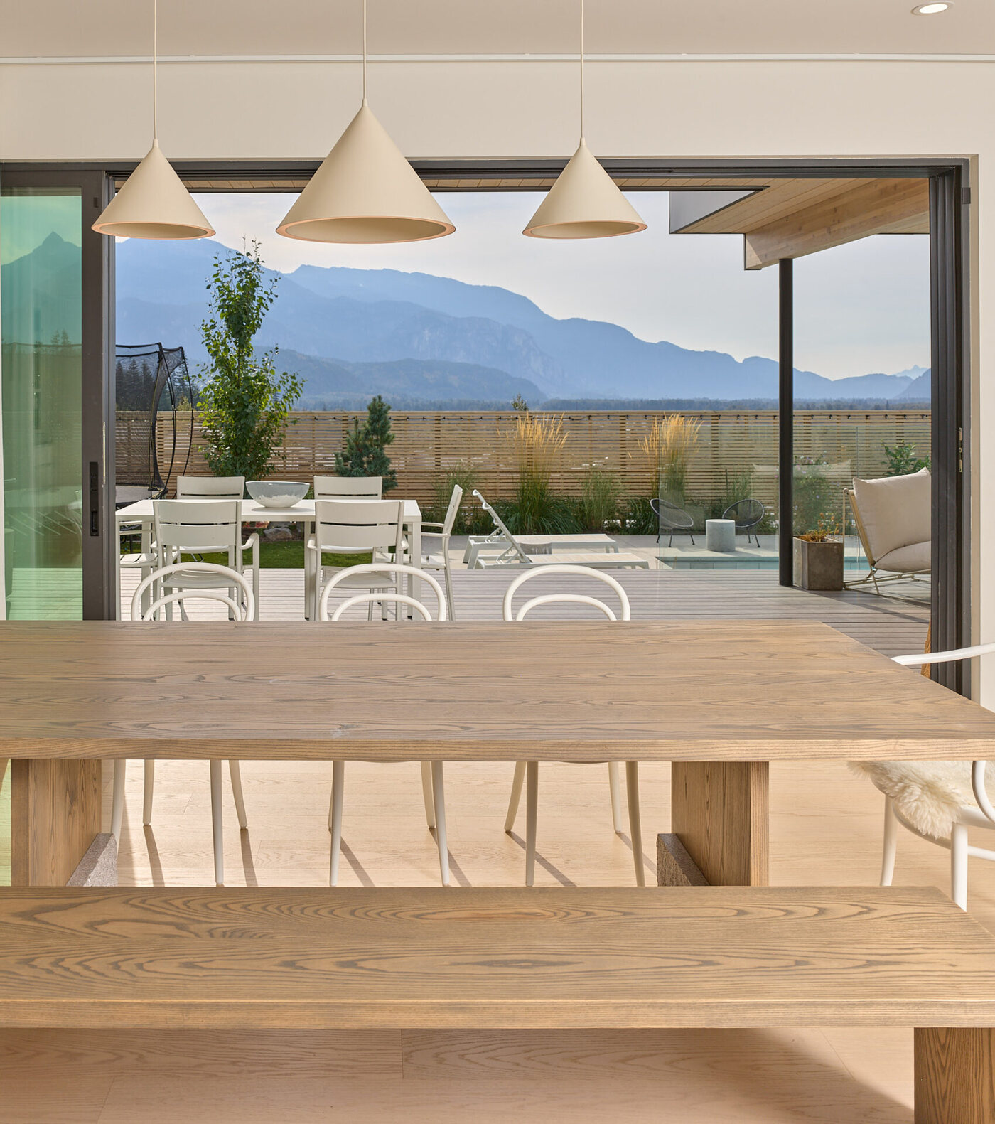 Skyridge: dining room of a Squamish custom home, doors open to the deck and mountains